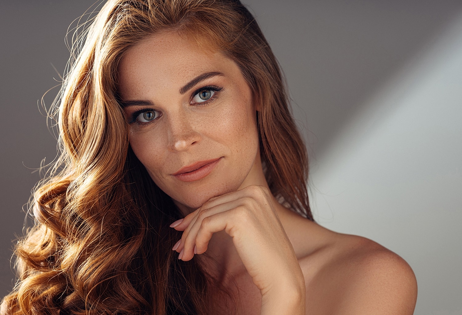 Lafayette facial plastic surgery model with long, wavy hair and serene expression.