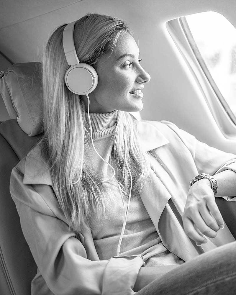 Lafayette facial plastic surgery model with headphones enjoying a flight.