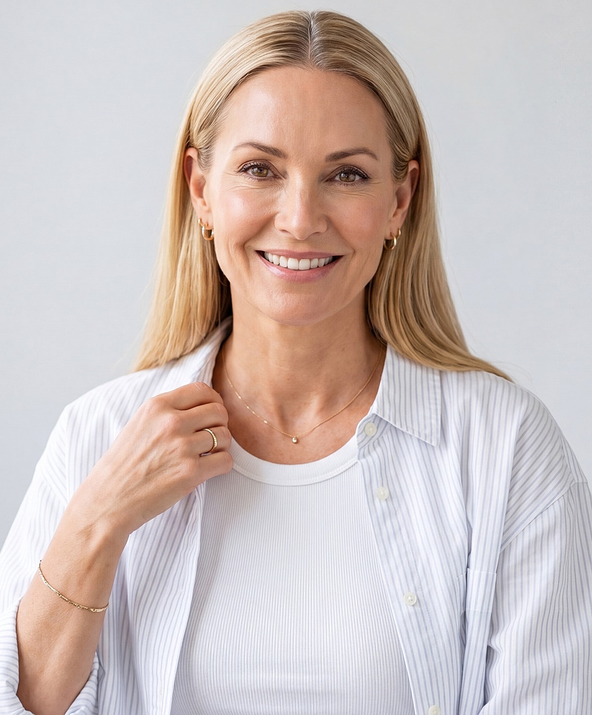 Smiling Lafayette facelift model in casual attire with jewelry.