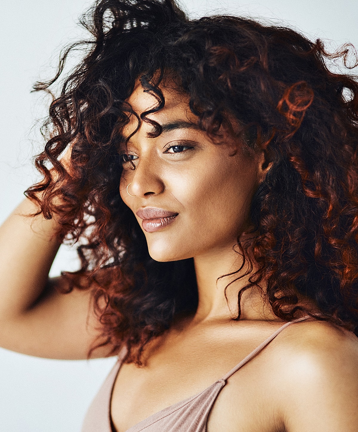 Lafayette Dermal Fillers model with curly hair in soft lighting.