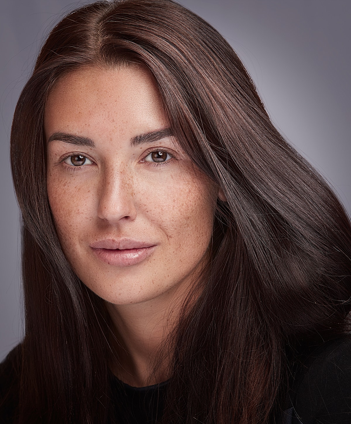 Lafayette Dysport model with long, dark hair and freckles.