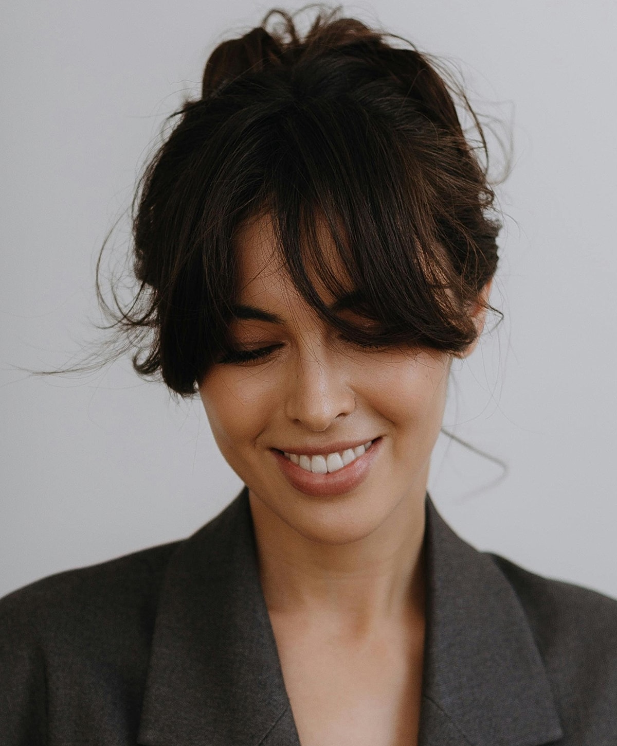 Lafayette Dermal Fillers model smiling with messy bun hairstyle.