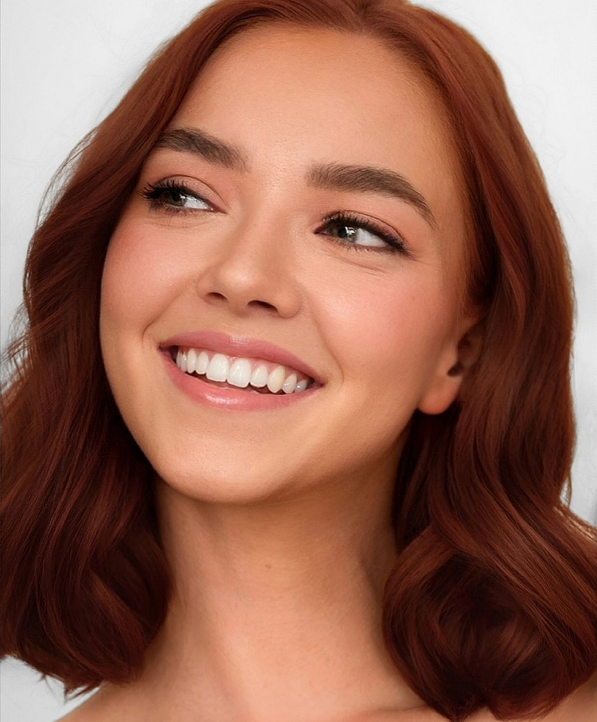 Smiling Lafayette BBL Laser model with wavy reddish-brown hair.