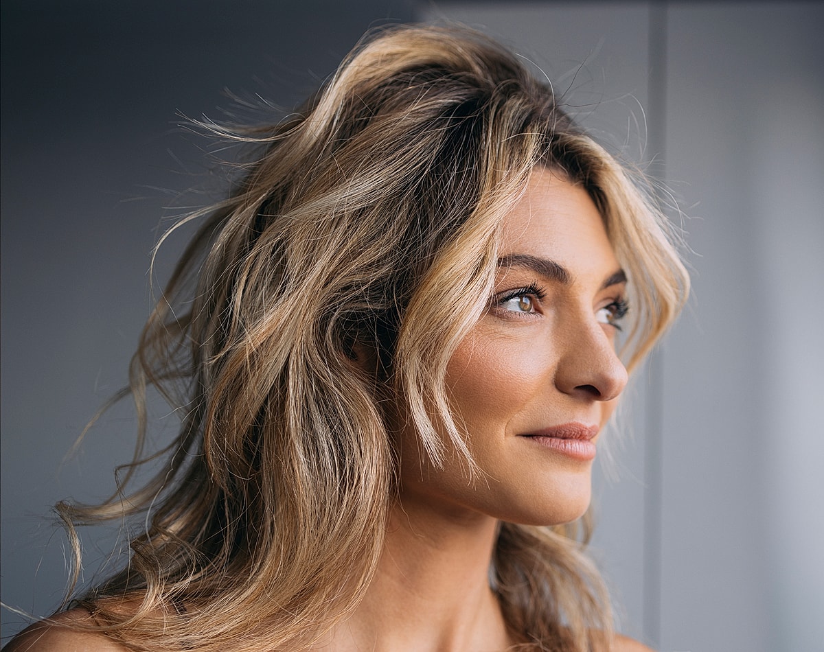 Lafayette facial plastic surgery model with long, wavy hair facing sideways.
